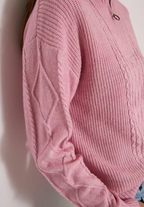 Pull rose en maille avec torsades et losanges, ajusté sur le buste.