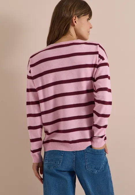 Pull à col bateau et rayures mellow rose melange Femme de dos portant un pull rayé rose et violet avec un jean bleu sur fond neutre.