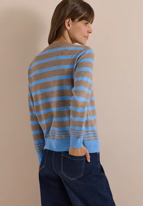 Pull à col rond et rayé urban taupe melange Une femme de profil porte un pull rayé beige et bleu clair assorti à un jean bleu foncé.