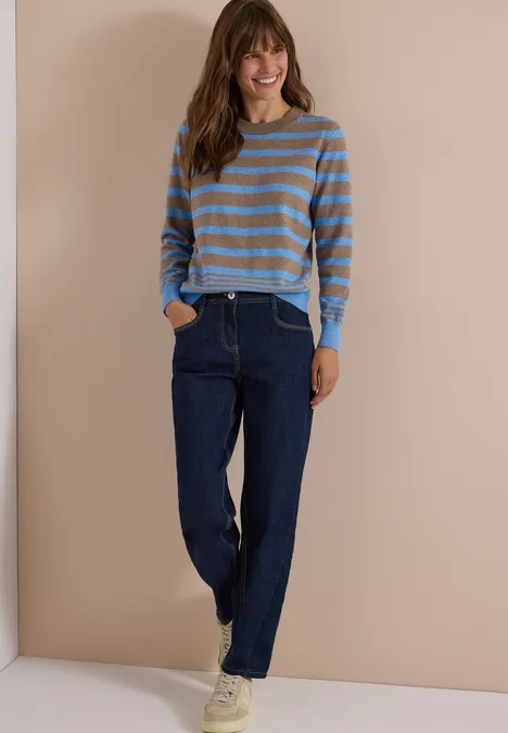 Pull à col rond et rayé urban taupe melange Femme en pull rayé et jean devant un mur beige, style décontracté, mains dans les poches, baskets blanches.