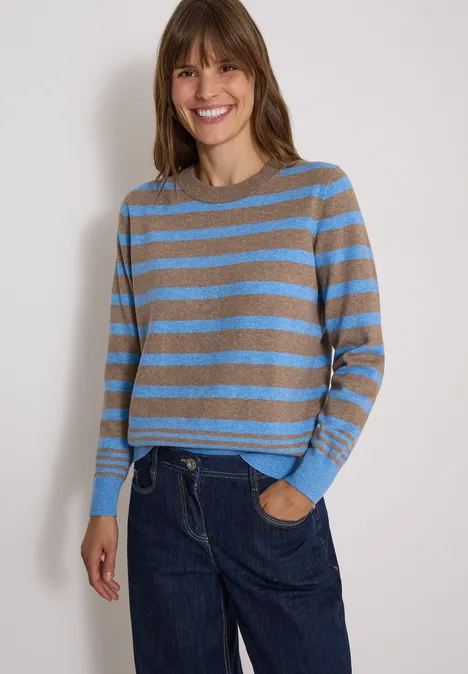 Pull à col rond et rayé urban taupe melange Une femme sourit en pull à rayures bleu et gris avec un jean.