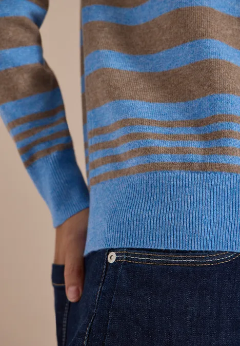 Pull à col rond et rayé urban taupe melange Gros plan sur un pull rayé marron et bleu porté avec un jean et une main dans la poche.