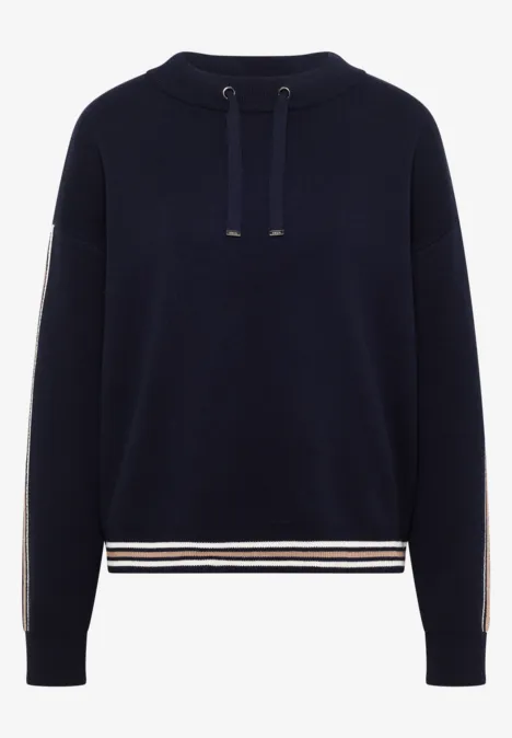 Dunkelblauer Pullover mit Kapuzenkordeln und weißen sowie beigen Streifen am Saum und an den Ärmeln.