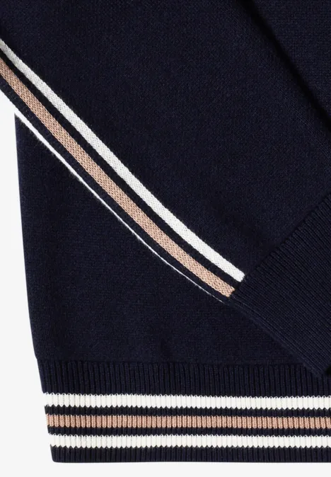 Dunkelblauer Strickpullover mit weißen und beigen Streifen an Ärmeln und Bündchen.