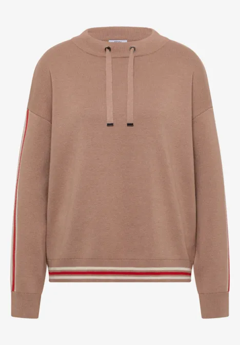 Beiger Hoodie mit Kapuze, roten Seitenstreifen an den Ärmeln und rot-weiß gestreiftem Saum.