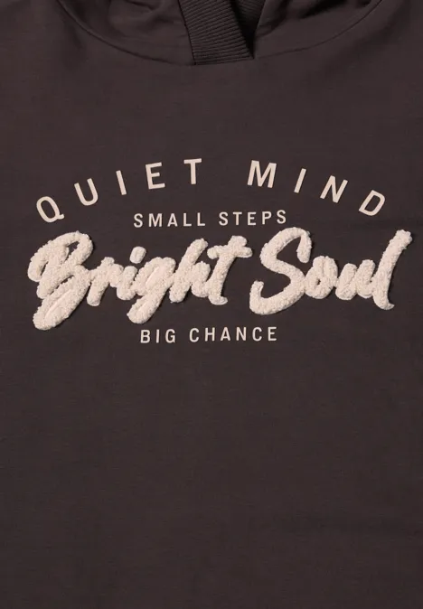 Donker shirt met witte tekst: 'Quiet Mind, Small Steps, Bright Soul, Big Chance'.