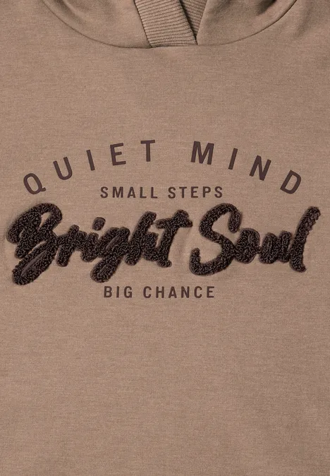 Beige Kapuzenpullover mit dem Schriftzug 'Quiet Mind, Small Steps, Bright Soul, Big Chance'.