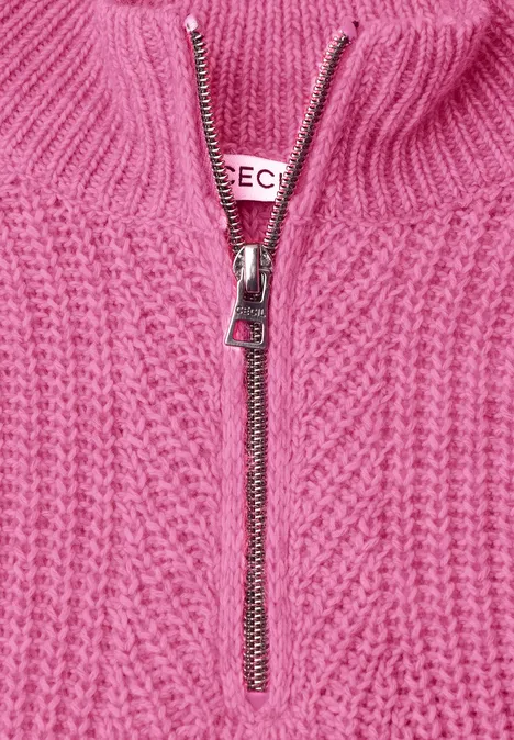 Trui met rits pink flash melange Nahaufnahme eines rosa Strickpullovers mit Zopfmuster und silbernem Reißverschluss.
