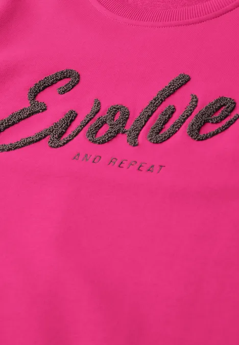 Sweatshirt mit Rundhals und Wording pink flash Pinkes T-Shirt mit schwarzem Schriftzug 'Evolve' und kleinem 'and repeat'.