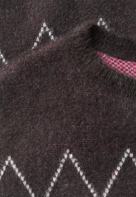 Ein dunkler Pullover mit weißem Zickzackmuster und pinkem Innenfutter am Kragen.