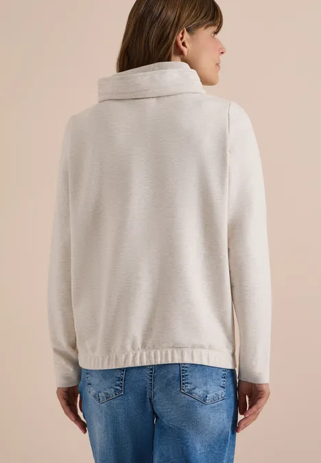Sweatshirt mit Kapuze und Artwork light cashmere beige melange Frau von hinten in kremfarbenem Strickjacke mit breitem Kragen und blauen Jeans.