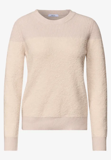 Beige damestrui van zacht, pluizig materiaal met ronde hals en lange mouwen.
