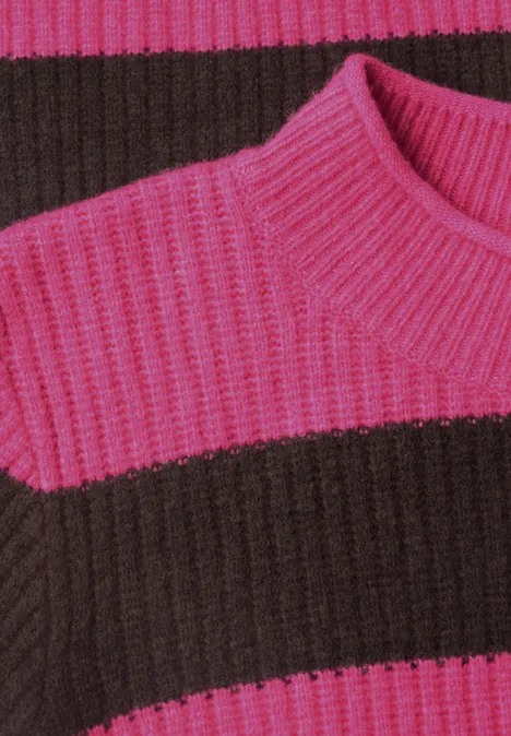 Gros plan d'un pull en maille côtelée à larges rayures roses et marron.