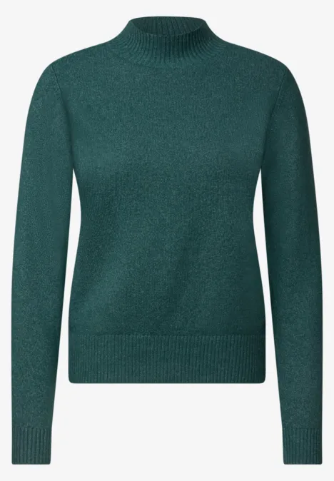 Un pull vert foncé à col montant, à manches longues, en maille côtelée et matière douce.