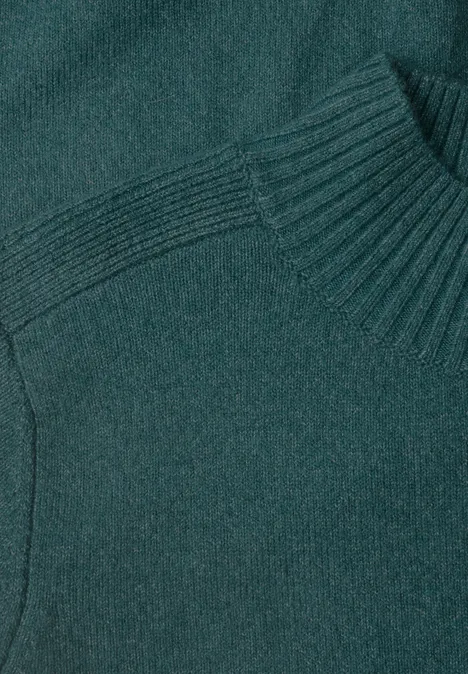 Pull en maille vert émeraude avec col montant et côtes fines.