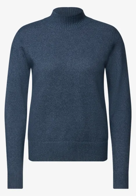 Un pull bleu foncé à col roulé, manches longues, coupe simple et élégante.