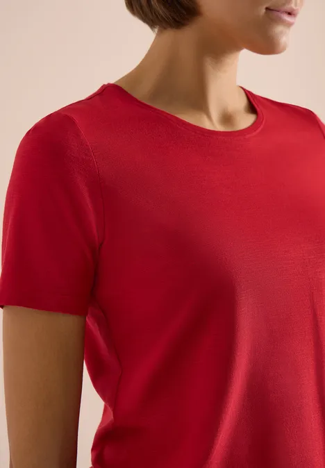 Basic T-Shirt mit Rundhals in Unifarbe tamarillo red Nahaufnahme eines weiblichen Oberkörpers in rotem, kurzärmeligen T-Shirt.