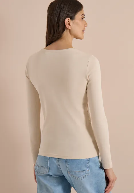 Basic Langarm Shirt mit Rundhals pearl beige Rückansicht einer Frau in beigem Langarmshirt und blauer Jeans vor neutralem Hintergrund.