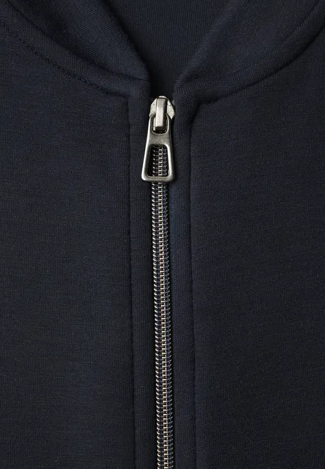 Nahaufnahme eines Metallreißverschlusses an einer dunkelblauen Jacke.