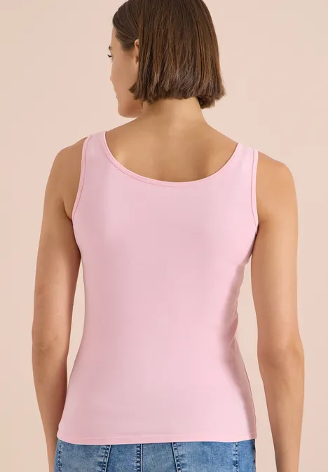 Vue de dos d'une femme portant un débardeur rose.