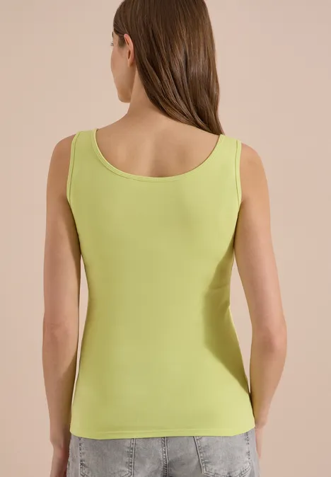 Basic Top aus reiner Baumwolle citrin green Rückansicht einer Frau in leuchtend grünem Top und Jeans.