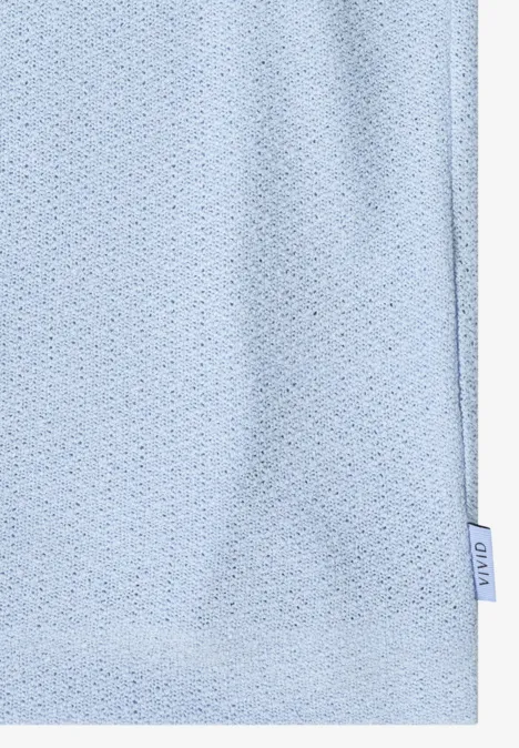 Lichtblauwe, ademende sportstof met kleine gaatjes en een zijlabel