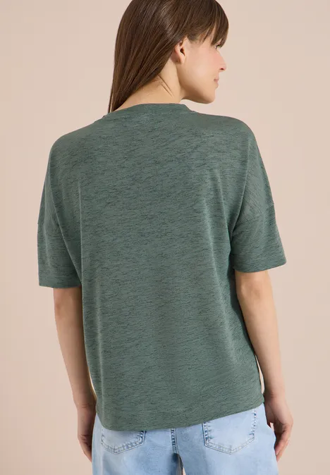 Persoon van achteren in groen T-shirt en blauwe spijkerbroek.