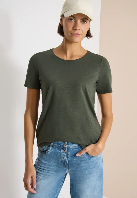 Basic T-Shirt mit Rundhals im 2er-Pack khaki/juicy lime Frau trägt dunkelgrünes T-Shirt mit Rundhalsausschnitt und blaue Jeans.