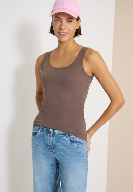 Basic Top mit Rundhals im 2er-Pack urban taupe/white Person in braunem Tanktop und blauen Jeans steht vor neutralem Hintergrund, Hände hinterm Rücken.