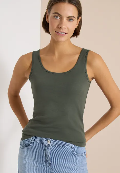 Basic Top mit Rundhals im 2er-Pack khaki/juicy lime Eine Frau trägt ein olivgrünes Tanktop und helle Jeans, vor neutralem Hintergrund.