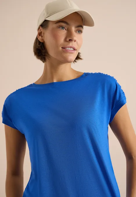 Kurzarm Shirt mit Boatneck und Raffung surf blue Person mit leuchtend blauem T-Shirt und Baseballcap vor neutralem Hintergrund.