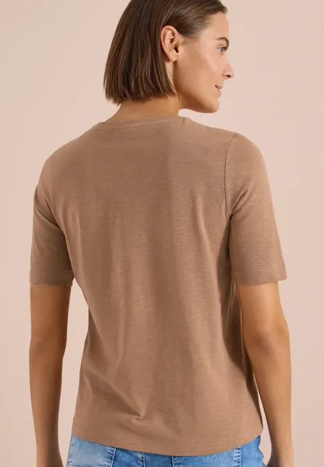 Basic T-Shirt mit Kurzarm und V-Neck creamy mocha Frau von hinten in hellbraunem Kurzarmshirt vor neutralem Hintergrund.