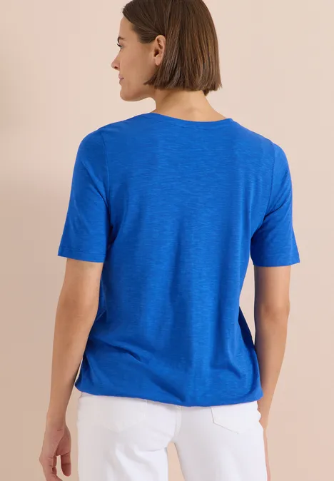 Kurzarm T-Shirt im Tunika-Look surf blue Rückansicht einer Frau in blauem T-Shirt und weißer Hose vor hellem Hintergrund.