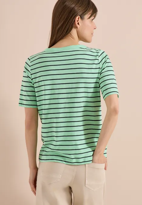 Frau von hinten in grün-schwarz gestreiftem T-Shirt und heller Hose