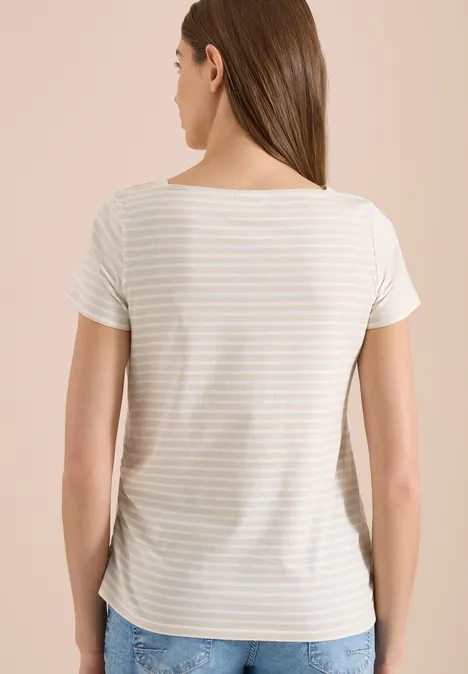 Frau von hinten in kurzärmligem, cremeweiß-beige gestreiftem T-Shirt vor hellem Hintergrund.