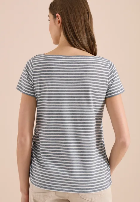 Frau von hinten in kurzärmligem blau-weiß gestreiftem T-Shirt vor beigem Hintergrund