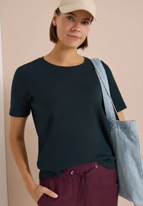 Basic T-Shirt in Rippstruktur deep petrol blue Person trägt schwarzes T-Shirt und lila Hose, mit Stofftasche über der Schulter.