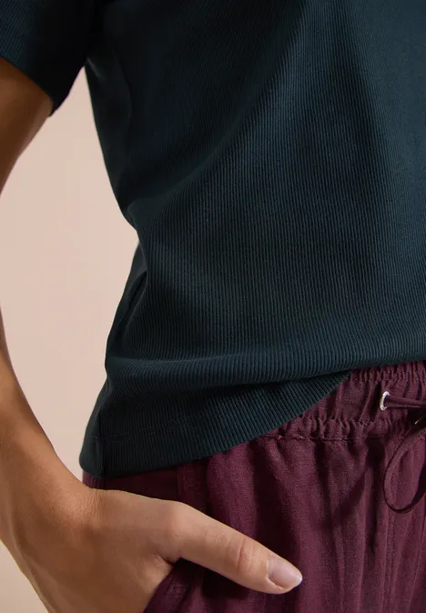Basic T-Shirt in Rippstruktur deep petrol blue Person trägt ein dunkelblaues Shirt und bordeauxrote Hose, Hand in Tasche.