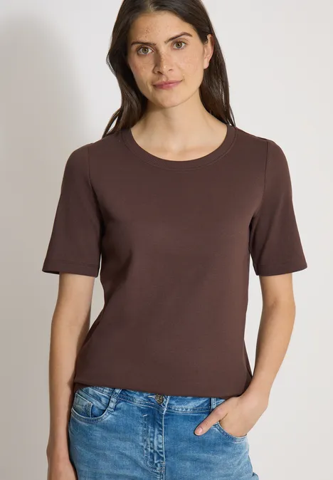 Basic Shirt met geribde textuur brown cacao Vrouw draagt bruin T-shirt met korte mouwen en blauwe spijkerbroek, hand in de zak.