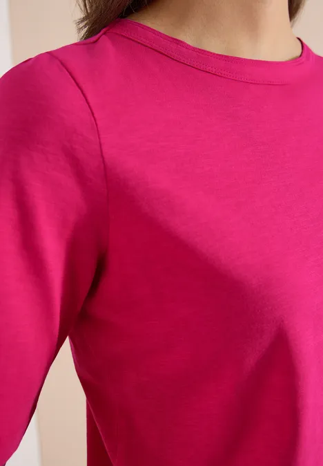 Detail van een felroze T-shirt met ronde hals zonder patroon