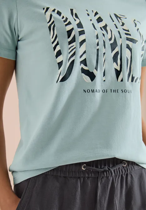 Koszulka z okrągłym dekoltem i nadrukiem z przodu crystal mint Jasnozielony T-shirt z nadrukiem 'DIVE' w paski i napisem 'Nomad of the Soul', do tego ciemne spodenki.