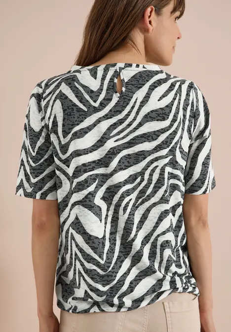 Achteraanzicht van een vrouw in een kort mouwtop met zwart-wit zebraprint.