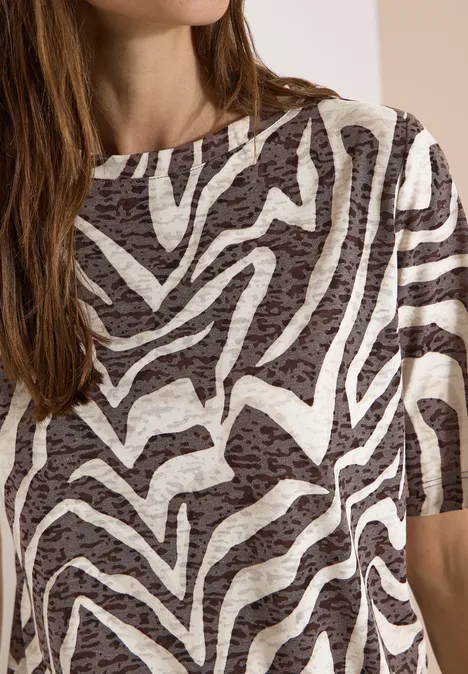 T-Shirt in Ausbrenner-Optik brown cacao Eine Frau trägt ein kurzärmeliges Shirt mit Zebra-ähnlichem Schwarz-Weiß-Muster.