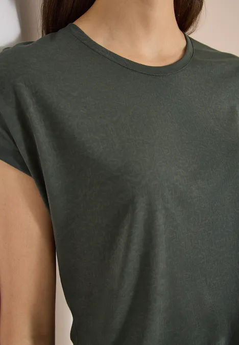 Nahaufnahme eines dunkelgrünen, kurzärmeligen T-Shirts an einer Person