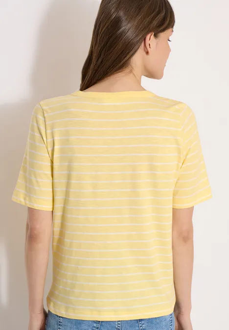 Une femme de dos porte un T-shirt jaune à rayures blanches.