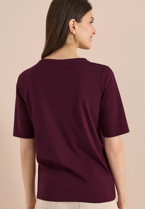 Basic Shirt met boothals sweet grape red Vrouw van achteren in een bordeauxrood T-shirt voor neutrale achtergrond.