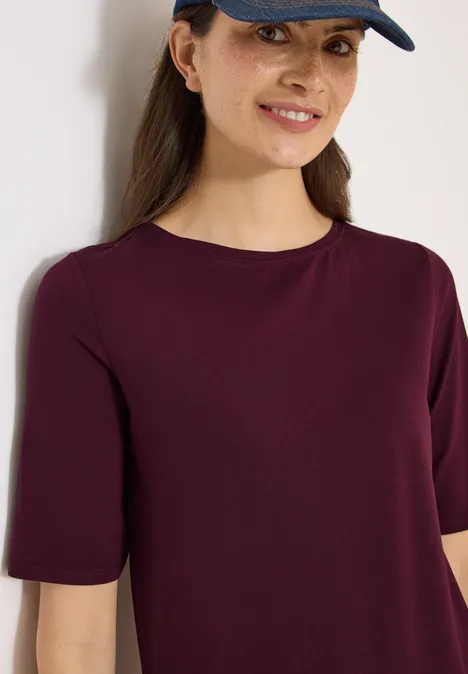 Basic Shirt met boothals sweet grape red Vrouwelijke bovenlijf met donkerrood T-shirt en zwarte pet, gezicht vaag