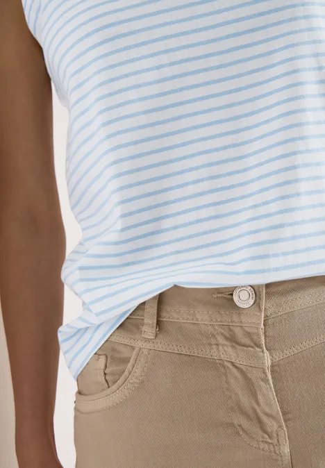 Weißes Top mit hellblauen Streifen kombiniert mit einer beigen Hose.
