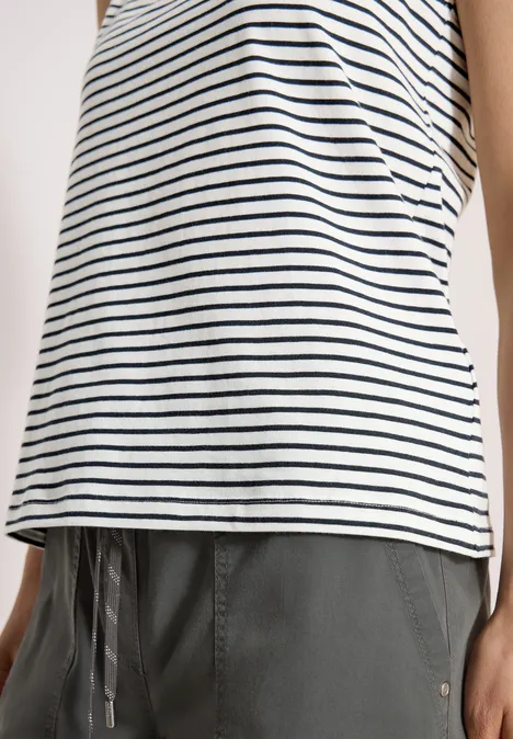 Frau trägt weiß-blau gestreiftes Top und graue Hose mit Kordelzug