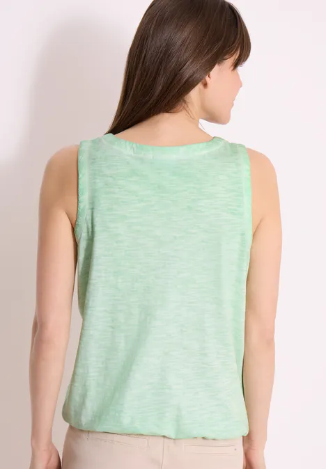 Frau von hinten in ärmellosem, hellgrünem Top vor hellem Hintergrund.